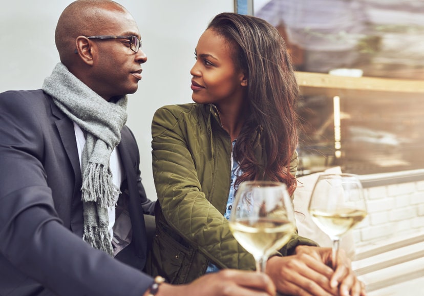 Homem e mulher se encontrando tomando uma taça de vinho branco 