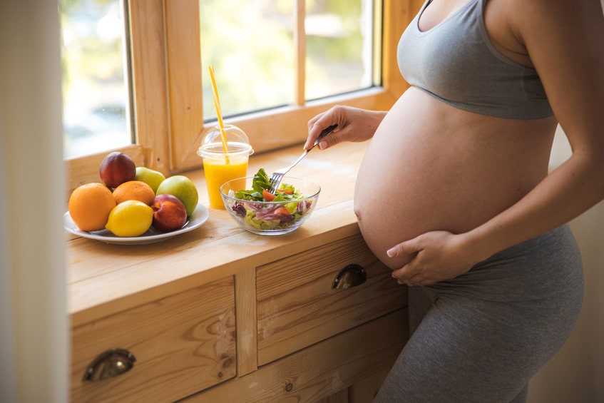 Mulher grávida comendo frutas