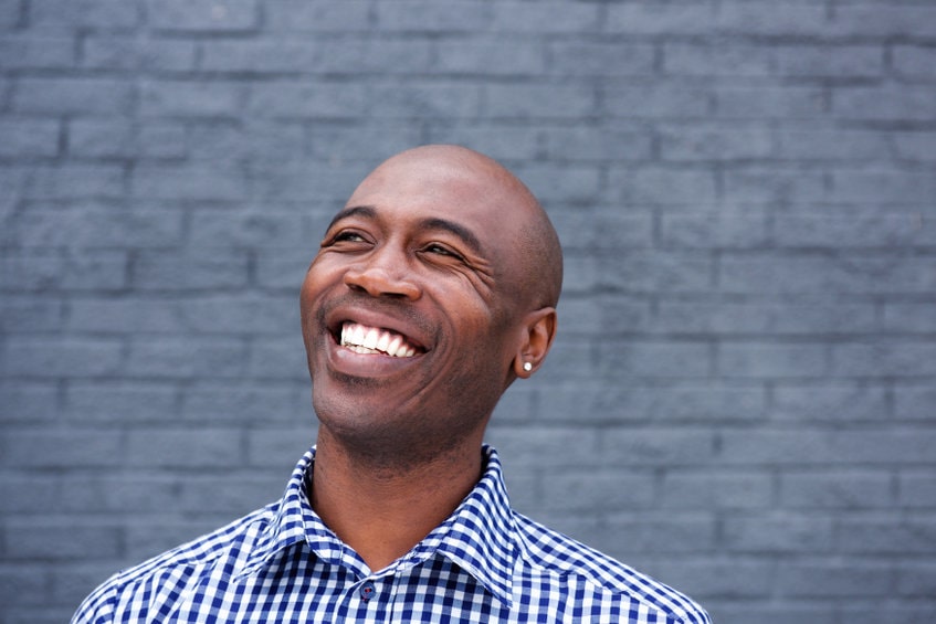 Homem sorrindo representando um dos benefícios da masturbação que é melhorar o humor