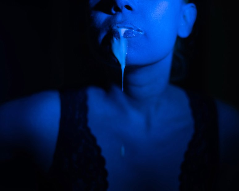 mulher cuspindo ao invés de engolir sêmen. Aparece apenas a boca dela pra baixo e a foto está em azul