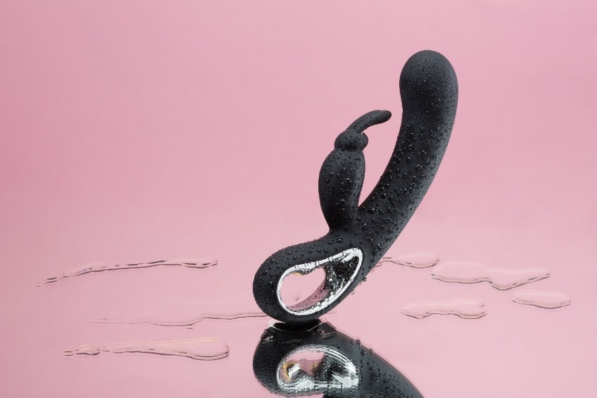 Vibrador Rabbit preto no fundo rosa claro